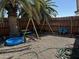 Shaded and fenced backyard with play set, gravel landscaping and shade tree at 433 S 113Th Pl, Mesa, AZ 85208