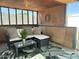 Enclosed patio with wicker seating, pillows, and a tropical-patterned area rug at 433 S 113Th Pl, Mesa, AZ 85208