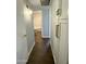 Hallway with wood look floors and white cabinets leads to bathroom at 433 S 113Th Pl, Mesa, AZ 85208