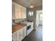 Functional laundry room with overhead cabinets, butcher block countertops, modern washer and dryer, and wood look floors at 433 S 113Th Pl, Mesa, AZ 85208
