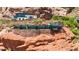Modern home showcases expansive glass walls and a stone foundation built into the unique red rock landscape at 4925 E Red Rock Dr # 43, Phoenix, AZ 85018