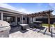 Backyard patio with pergola covering a jacuzzi, grill, and stylish outdoor seating at 6802 S 44Th Pl, Phoenix, AZ 85042