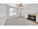 Bright living room featuring a fireplace, large window, carpet and a ceiling fan at 750 E Northern Ave # 2006, Phoenix, AZ 85020