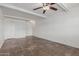 Open living space featuring neutral tile floors, white walls, ceiling fan, and access to other rooms at 8211 E Garfield St # J219, Scottsdale, AZ 85257