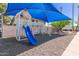 Charming community playground features a slide and swings under a vibrant blue shade structure at 8211 E Garfield St # J219, Scottsdale, AZ 85257