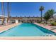Community pool with clear blue water, surrounded by lounge chairs and manicured landscaping at 8211 E Garfield St # J219, Scottsdale, AZ 85257