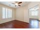 Comfortable bedroom features hardwood floors, window with shutters and a ceiling fan at 888 S 165Th Ln, Goodyear, AZ 85338