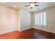 Bright bedroom features a ceiling fan, window with shutters and hardwood floors at 888 S 165Th Ln, Goodyear, AZ 85338