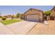 Beige single-story home featuring a two-car garage and wide driveway at 888 S 165Th Ln, Goodyear, AZ 85338