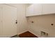 Well-lit laundry room featuring ample storage with white cabinets and a convenient, sturdy door at 888 S 165Th Ln, Goodyear, AZ 85338