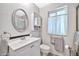 White bathroom with vanity, toilet, linen cabinet, and frosted glass enclosed shower at 10205 W Royal Oak Rd, Sun City, AZ 85351