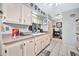 Bright kitchen features a window with sink, white cabinets and tile floors at 10205 W Royal Oak Rd, Sun City, AZ 85351