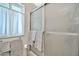 Bathroom shower with opaque glass sliding doors and a small window with a sheer curtain at 10205 W Royal Oak Rd, Sun City, AZ 85351