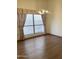 Empty dining room showcasing hardwood floors, natural light from the large windows, and chandelier lighting at 1249 E Commerce Ave, Gilbert, AZ 85234