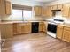 Classic kitchen with wood cabinets, laminate countertops, and black appliances at 1249 E Commerce Ave, Gilbert, AZ 85234