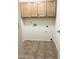 Bright laundry room features tile flooring, wooden cabinets, and utility connections at 1249 E Commerce Ave, Gilbert, AZ 85234