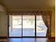 Bright living room featuring wood floors, large windows, and access to a screened patio at 1249 E Commerce Ave, Gilbert, AZ 85234
