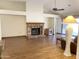 Open living room featuring hardwood flooring, a brick fireplace, and a ceiling fan at 1249 E Commerce Ave, Gilbert, AZ 85234