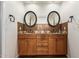 Bathroom featuring double sink, wood cabinets, decorative tile backsplash, and black framed mirrors at 13600 N Fountain Hills Blvd # 501, Fountain Hills, AZ 85268