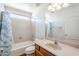 Bright bathroom featuring a shower-tub combination, neutral walls, and a classic wood vanity at 16136 W Durango St, Goodyear, AZ 85338