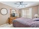 Cozy bedroom with a ceiling fan, plush carpet, and a large window allowing natural light at 16136 W Durango St, Goodyear, AZ 85338
