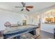 Bright game room with a pool table, ceiling fan, and elegant staircase access at 16136 W Durango St, Goodyear, AZ 85338