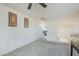 Bright hallway with soft carpet and a ceiling fan leads to bedrooms, creating an inviting space at 16136 W Durango St, Goodyear, AZ 85338