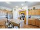 Traditional kitchen with an island, stainless steel appliances, and wood cabinets offers ample storage at 16136 W Durango St, Goodyear, AZ 85338