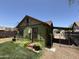 The home's exterior features lush greenery, a metal roof and a gated drive at 1813 E Willetta St, Phoenix, AZ 85006