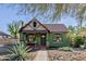 Charming home with a rust-colored corrugated metal roof, green painted brick, and a well-manicured front yard at 1813 E Willetta St, Phoenix, AZ 85006