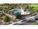 Stunning aerial view of a community pool with palm trees, a covered area, and a playground at 18747 W Monterosa St, Litchfield Park, AZ 85340