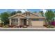 Charming single-story home with stone accents, a two-car garage, and beautifully landscaped front yard at 18747 W Monterosa St, Litchfield Park, AZ 85340