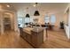 Open kitchen with a large island, farmhouse sink, modern lighting, and an adjacent dining/living area at 18747 W Monterosa St, Litchfield Park, AZ 85340
