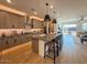 Stylish kitchen boasts a spacious island with bar stools, modern pendant lighting, and stainless steel appliances at 18747 W Monterosa St, Litchfield Park, AZ 85340