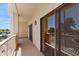 A large, covered balcony with railing and large sliding glass doors, overlooking lush landscaping at 19400 N Westbrook Pkwy # 220, Peoria, AZ 85382