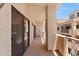 Covered balcony with textured walls, metal railings, and sliding door access, offering serene views at 19400 N Westbrook Pkwy # 220, Peoria, AZ 85382