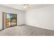 An open bedroom space with a ceiling fan and sliding glass door to a balcony at 19400 N Westbrook Pkwy # 220, Peoria, AZ 85382