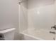 Bright bathroom featuring a tub with white tile surround, a shower head, and a toilet at 2000 N 36Th St # 10, Phoenix, AZ 85008