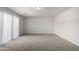 Open bedroom with neutral carpet, light walls, and sliding glass door access to the outdoors at 2000 N 36Th St # 8, Phoenix, AZ 85008