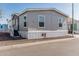 Charming single-story home with gray siding and steps to a new door at 2060 N Center St # 133, Mesa, AZ 85201
