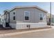 Charming single-story home with gray siding and steps to a new door at 2060 N Center St # 133, Mesa, AZ 85201