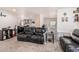 Inviting living room showcasing dark leather couches and a view into the kitchen at 2060 N Center St # 133, Mesa, AZ 85201