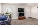 Cozy living room with a large window, plush carpet, and stacked TVs on a wooden chest at 2060 N Center St # 133, Mesa, AZ 85201