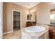 Bathroom featuring a walk-in closet, vanity with granite countertop, and a deck-mounted bathtub at 2062 W Roy Rogers Rd, Phoenix, AZ 85085