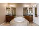 Primary bath features a large soaking tub set in tile, dual sinks and mirrors, and tile flooring at 2062 W Roy Rogers Rd, Phoenix, AZ 85085