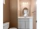 This half bath features a white vanity with a quartz countertop and a framed oval mirror at 2062 W Roy Rogers Rd, Phoenix, AZ 85085