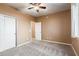 Bedroom featuring carpet floors, ceiling fan, walk-in closet, and window with curtain letting in sunlight at 2062 W Roy Rogers Rd, Phoenix, AZ 85085