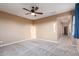 The empty bedroom features neutral carpet, a ceiling fan, and a bright window with curtains at 2062 W Roy Rogers Rd, Phoenix, AZ 85085