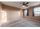 A carpeted bedroom includes a ceiling fan and window with curtains at 2062 W Roy Rogers Rd, Phoenix, AZ 85085