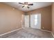 Bedroom featuring carpet floors, ceiling fan, walk-in closet, with sunlight streaming from the open door at 2062 W Roy Rogers Rd, Phoenix, AZ 85085